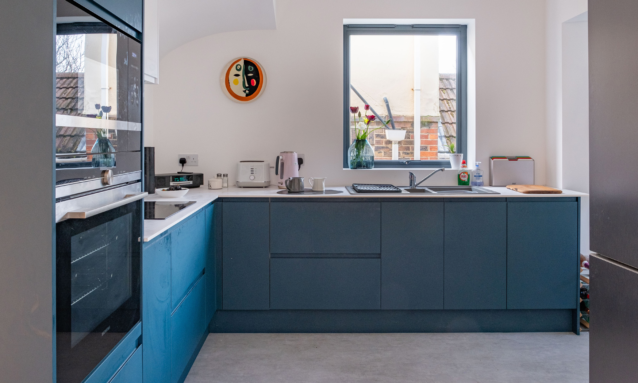 Contemporary blue kitchen with white worktops